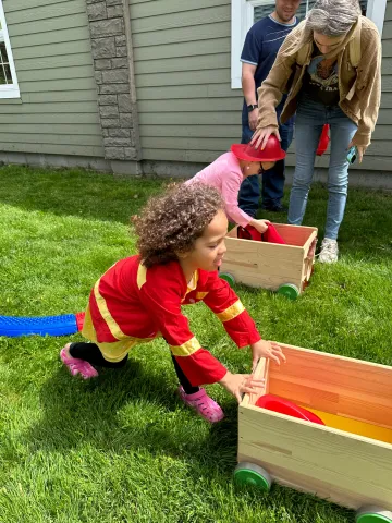 Kids pushing carts in junior fire fighter obstacle course