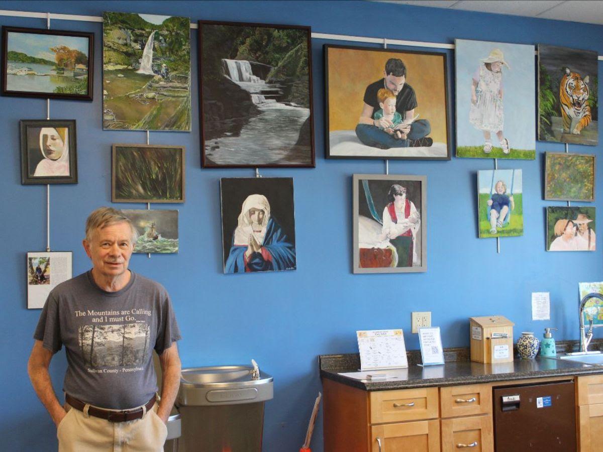 Artist Brad Schwebler posed in front of his paintings.