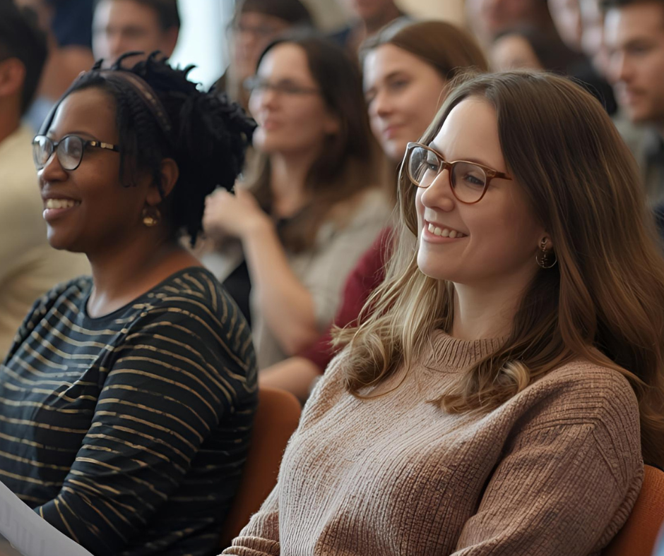 photo of people seated in an audience listening to a presentation